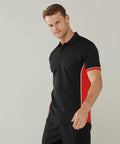 A man wearing a Finden & Hales LV355 with red and white side panels stands against a plain background.