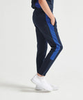 Person wearing Finden & Hales LV883 navy and blue joggers with white sneakers, standing against a plain background.