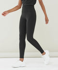 Person wearing black Finden & Hales LV896 high-waisted leggings and white sneakers stands against a plain background. The upper body is cropped out of the frame.