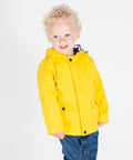 A young child with curly blonde hair wearing a bright yellow raincoat and blue jeans stands against a plain white background in the Larkwood LW35T.