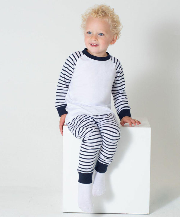 A young child with curly hair, dressed in Larkwood LW72T pajamas, sits on a white cube against a plain background.