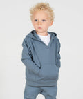 A young child with curly blond hair and blue eyes wears a light blue LW802 hoodie and matching pants by Larkwood, standing against a plain white background.