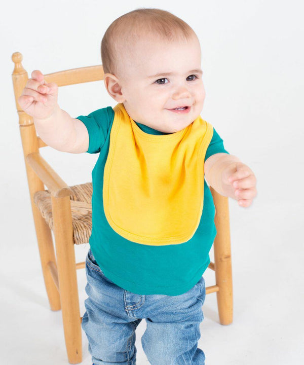A baby wearing a yellow bib and teal shirt, stands and stretches arms out near a Larkwood LW82T.
