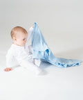 A baby in a white outfit sits on the floor, holding up a light blue Larkwood LW900.