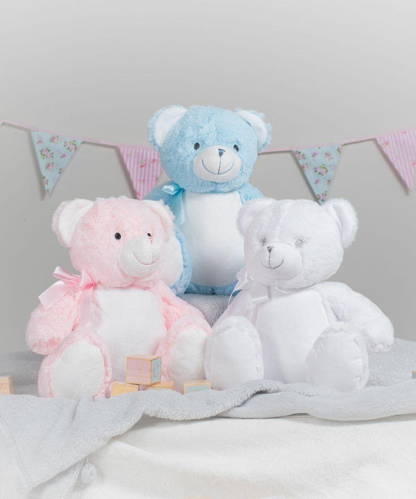 Three Mumbles MM556 teddy bears, one pink with a bow, one blue with a bow, and one white, sit on a soft blanket with pastel-colored bunting in the background.