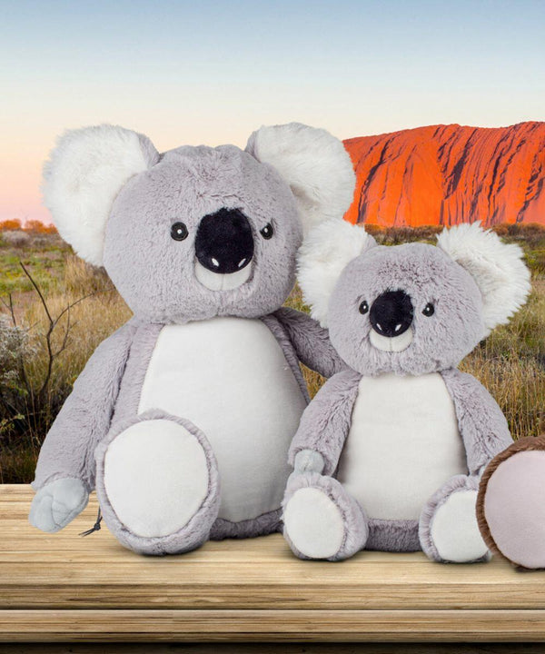 Two MM574 by Mumbles, one larger and one smaller, are placed on a wooden surface with a scenic backdrop.