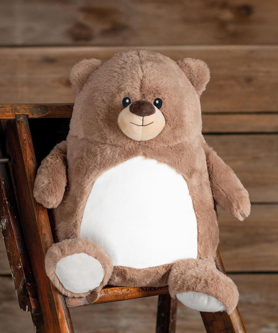 The Mumbles Zippie brown bear, featuring round ears, black eyes, a small brown nose, and a white tummy, sits on a wooden step-ladder against a wooden wall background.