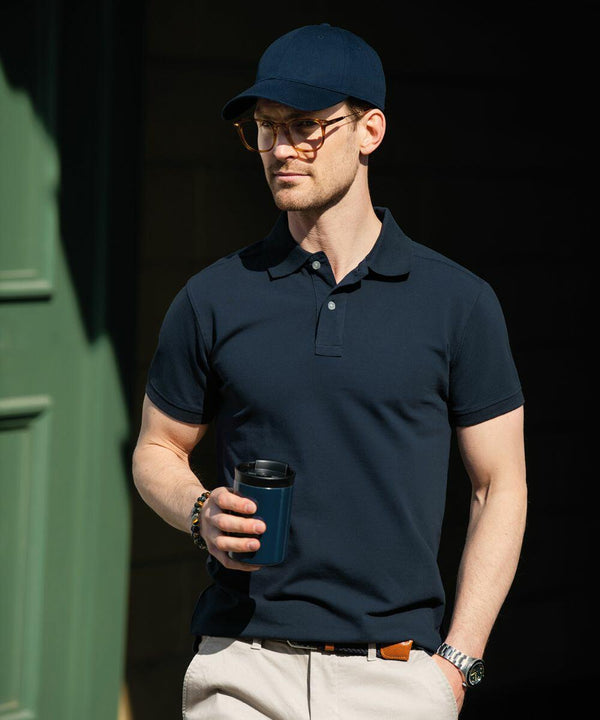 Man in a dark polo shirt and cap holds a Nimbus NB37M while standing outdoors.