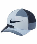 A Nike NK324 baseball cap featuring a light blue and dark blue patchwork design with a black swoosh logo on the front.