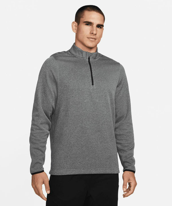 A man stands facing forward, wearing a gray Nike NK355 quarter-zip pullover and black pants, against a plain white background.