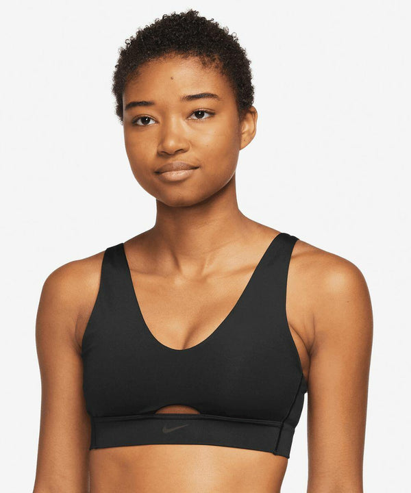 Person wearing a black Nike NK381 sports bra with a small cutout at the bottom center, standing in front of a white background.