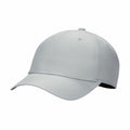 Introducing the Nike NK393: a light gray baseball cap featuring a curved visor and six-panel stitching. This cap is designed with a button on top and ventilation holes in each panel, while the underside of the visor presents a darker shade for contrast against the overall tone.