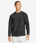 A man in a black Nike NK394 long-sleeved shirt stands against a plain white background. He is looking to the side with a neutral expression.