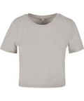 A light beige short-sleeve crop top T-shirt with a crew neckline and no visible logos or designs is displayed on a white background.