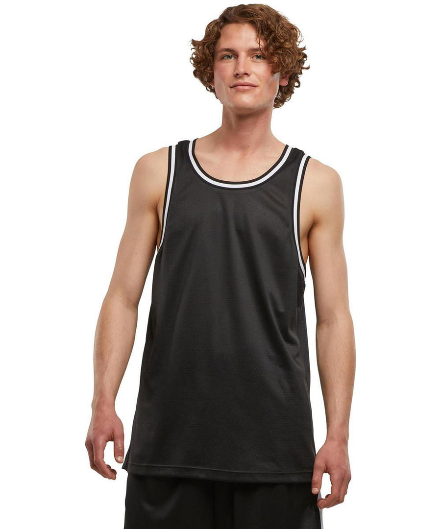 A person with curly hair wears the New Morning Studios mesh vest and black shorts, standing against a plain white background.