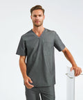 A man wearing a gray scrub top and pants stands against a white background, resting one hand on an Onna NN200.