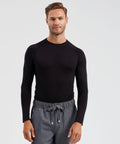 A man wearing a long-sleeved black Onna NN270 shirt and gray drawstring pants stands against a plain background, looking at the camera with a neutral expression.