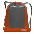 Introducing the OG025, an Ogio drawstring backpack showcasing a stylish two-tone design. It features a gray body accented with an orange border and includes a convenient front zippered pocket. The Ogio logo is prominently displayed at the bottom right, while sleek black drawstrings complete the look.