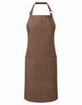 The Premier PR113 brown apron features two front pockets and adjustable neck straps, displayed against a white background.
