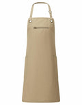 Introducing the PR121 by Premier: a tan apron featuring an adjustable neck strap, a convenient front pocket, and two side pockets.