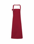 A plain red Premier apron, model PR130, featuring a neck strap and waist tie, displayed against a white background.