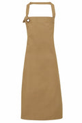 The Premier PR130 apron, in a plain brown color and halter neck design, features an adjustable loop and ring closure on one strap. The apron is simple in style and extends to knee length.
