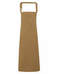 The Premier PR132 is a brown apron with an adjustable neck strap, equipped with a chest pocket and two side pockets.