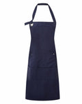 The Premier PR137 is a navy blue apron complete with a neck strap and a convenient front pocket. It includes an adjustable metal ring on one side of the neck strap, and its durable fabric makes it ideal for both kitchen and workshop use.