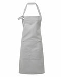The PR137 apron by Premier is a simple gray design with a neck strap and a spacious front pocket, showcased against a white background.