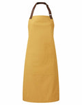 Introducing the Premier PR144: a durable yellow apron equipped with a brown adjustable neck strap and a spacious front pocket, ideal for use in both kitchen and workshop settings.