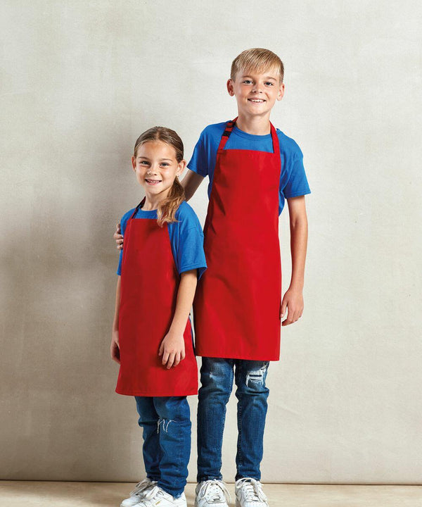 Two children wearing blue shirts and red aprons stand next to each other against a plain background. The older child has their arm around the younger one, showcasing Premier's PR145.