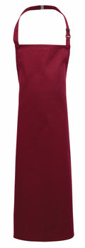 A Premier PR149 apron featuring a plain red design, complete with a neck strap and extended length.