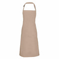 A beige full-length Premier PR150 apron with an adjustable neck strap and a simple design, hanging on a white background.