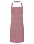 The Premier PR150 apron, featuring an adjustable neck strap, is displayed against a white background. The pink apron has a plain design without any visible pockets or patterns.