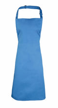 Premier's PR150 apron in plain blue features a neck strap and waist ties, showcased against a white background.