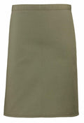 The Premier PR151 is a knee-length skirt in olive green, featuring a straight cut and crafted from smooth fabric. It boasts a simple, minimalist design with a waistband at the top.