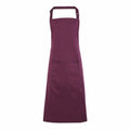 The Premier PR154 apron in maroon features an adjustable neck strap and a front pocket.