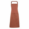 Against a white background hangs the Premier PR154 brown apron, featuring an adjustable neck strap and a spacious front pocket.