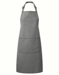 The Premier PR154 kitchen apron, featuring a neck strap and a large front pocket, is showcased against a simple white backdrop.