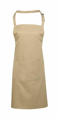 A Premier PR154 beige apron with an adjustable neck strap and a spacious front pocket, showcased on a plain white background.