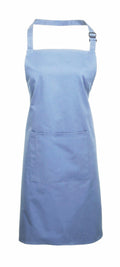 A Premier PR154 apron in blue, featuring a front pocket and an adjustable neck strap, is showcased against a plain white background.