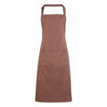 The Premier PR154 features a brown apron with a neck loop and waist ties. It includes a central pocket at the front and is made from smooth, durable fabric, making it ideal for cooking or crafting activities.