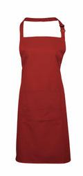 Product Description: The Premier PR154 apron, featuring a vibrant red color, includes a convenient halter neck strap and a spacious front pocket.