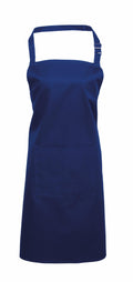 Premier's PR154 apron, featuring a plain blue design with a neck strap and front pocket, is displayed against a white background.