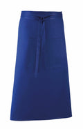 The Premier PR158 is a blue waist apron featuring a front pocket and tie strings. The fabric has a smooth texture, and the apron is designed with simplicity and functionality in mind.