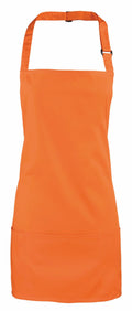 Premier's PR159 apron in orange, featuring an adjustable neck strap and two front pockets, displayed on a white background.