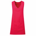 The Premier PR177 apron, featuring a sleeveless design in red with a V-neck and front pocket, is displayed against a white background.
