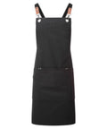 The Aprons product features a black design with two brown leather straps attached by metal rings and a large front pocket divided into two sections. It is displayed on a white background.