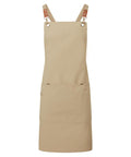 Aprons: Beige apron featuring brown adjustable straps, metal hardware, and a large front pocket with a smaller side section. Shown against a plain white background.