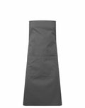 A plain PR190 apron from Premier, featuring front pockets in a dark gray color, is displayed flat against a white background, highlighting its simple and functional design.